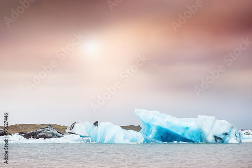 Blue icebergs in Jokulsarlon glacial lagoon at sunset.