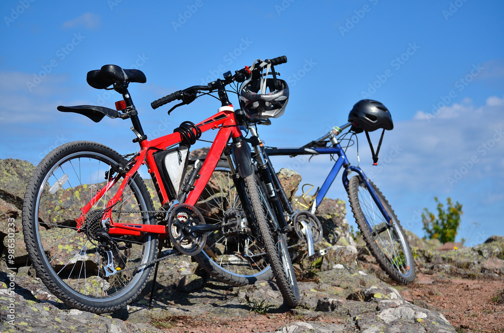 two mountain bikes standing in countryside two mountain bikes standing in countryside