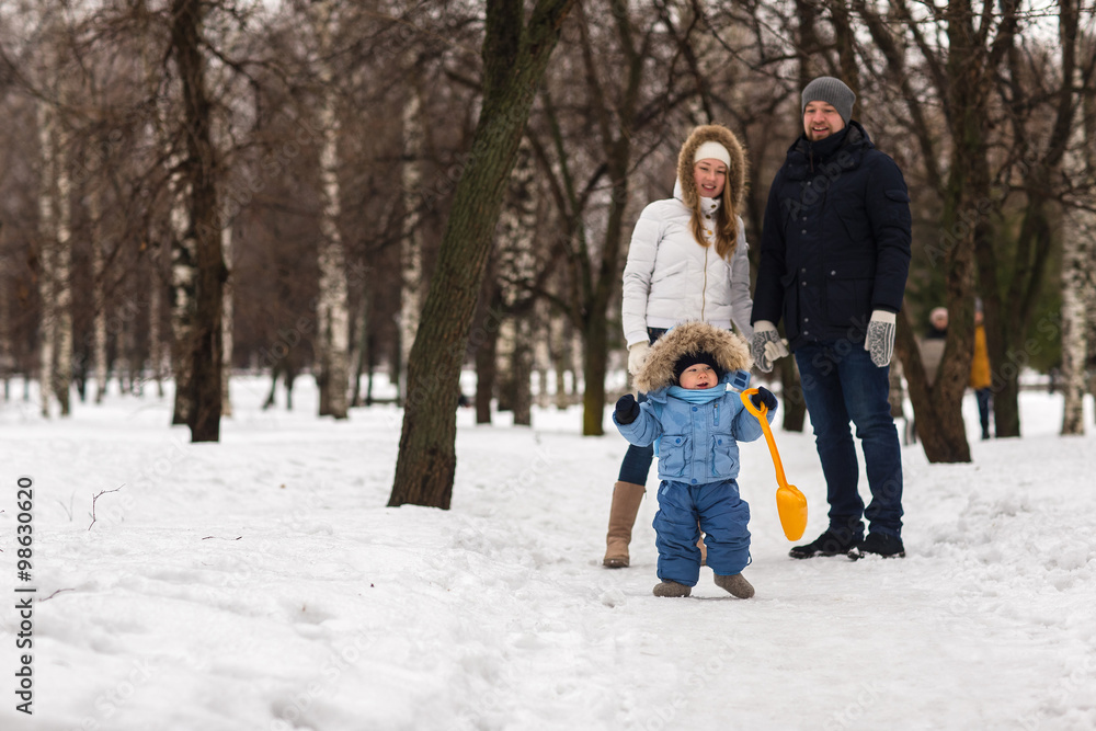 Fototapeta premium Happy young family walking in a winter park