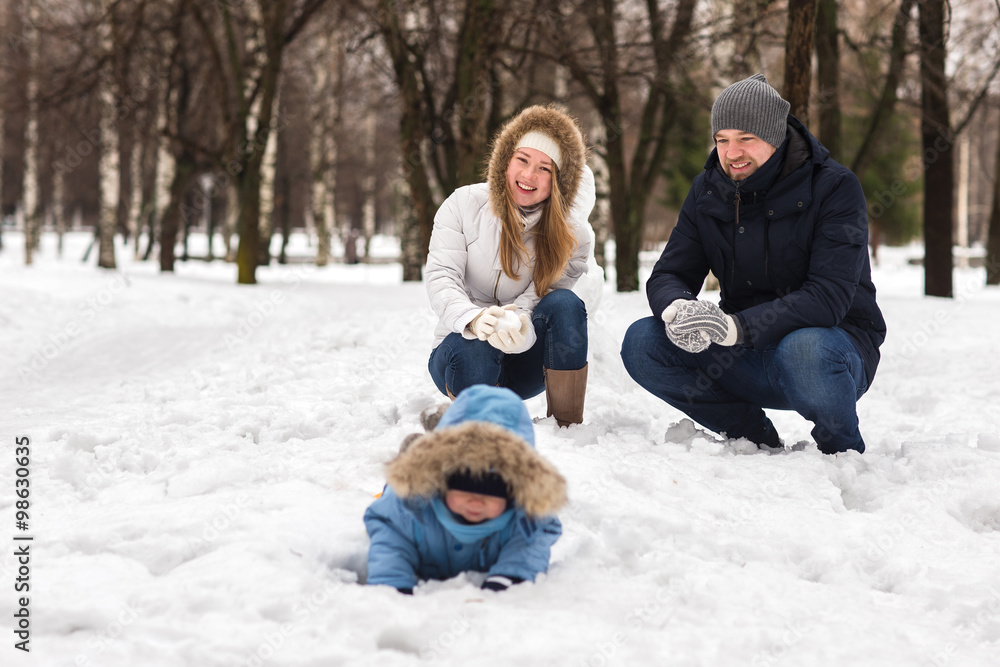 Obraz premium Happy young family walking in a winter park