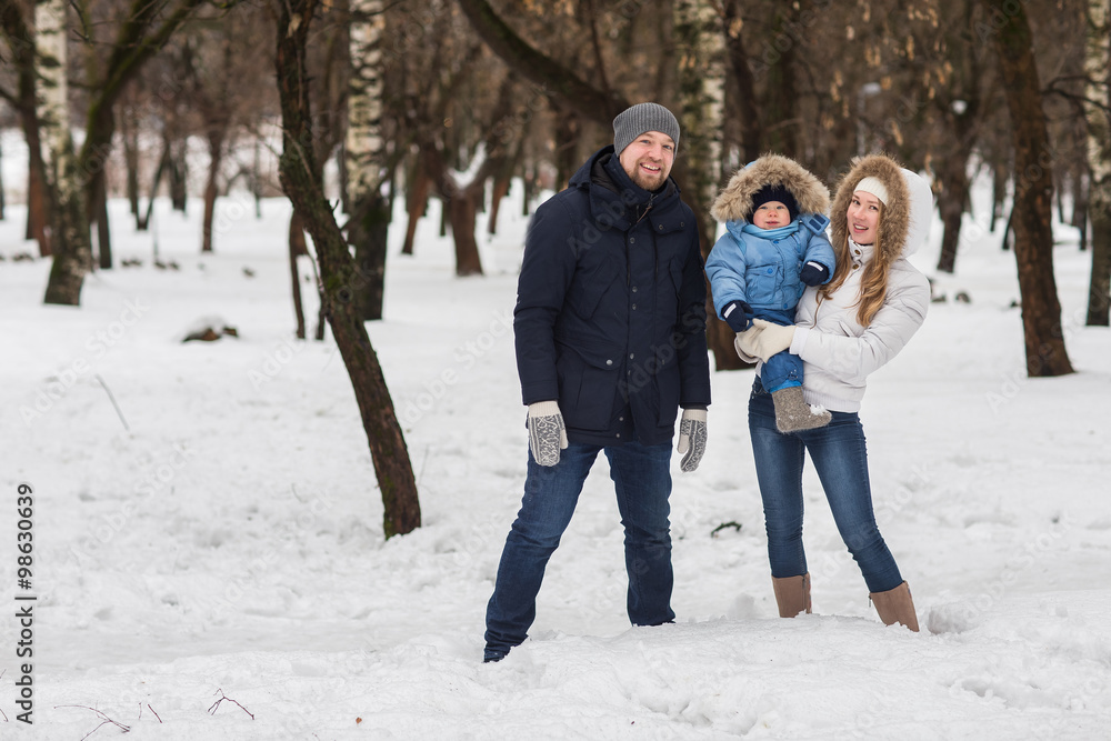 Happy young family walking in a winter park
