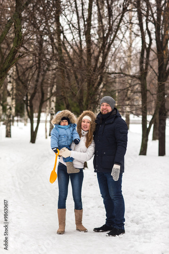 Happy young family walking in a winter park