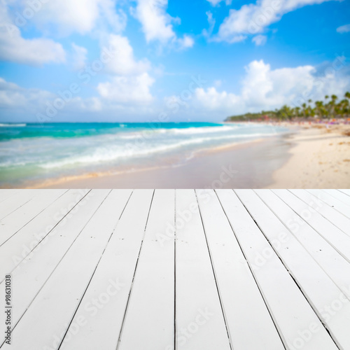 Empty white wooden pier with blurred beach