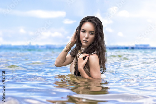 Beautiful young brunette woman outdoors portrait in the sea