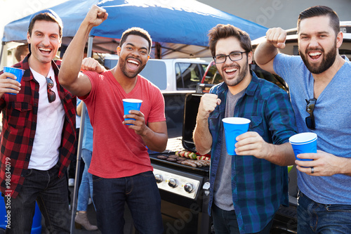 Canvas Print Group Of Male Sports Fans Tailgating In Stadium Car Park