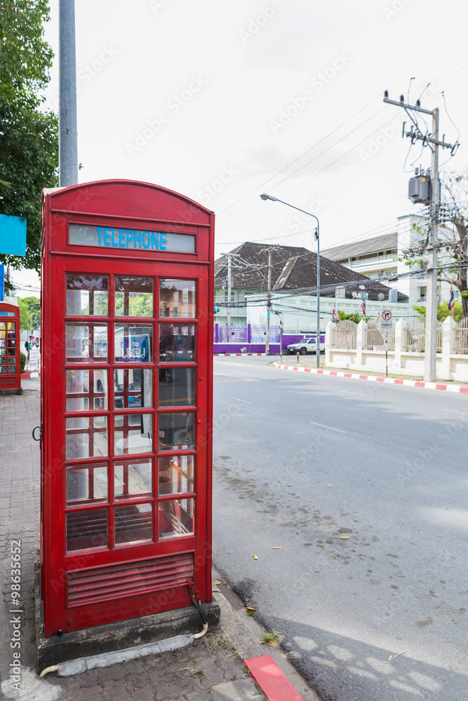 Red box of telephone near the road Red box of telephone near the road