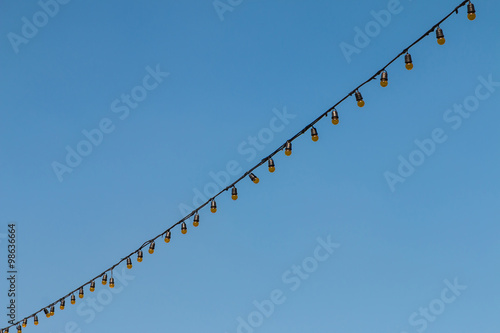 Closeup of the hanging light bulbs with blue sky 1