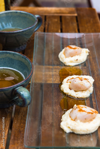 Close up of pan seared sea scallops and a cup of cider