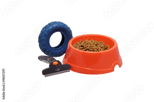 A bowl of dog food, toys and a comb.