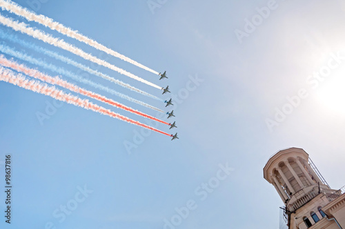 Six Sukhoi Su-25 (Frogfoot) single-seat twin-engine jet aircrafts fly with color smokes in form of Russian National Flag (tricolor) against blue sky background.
 photo