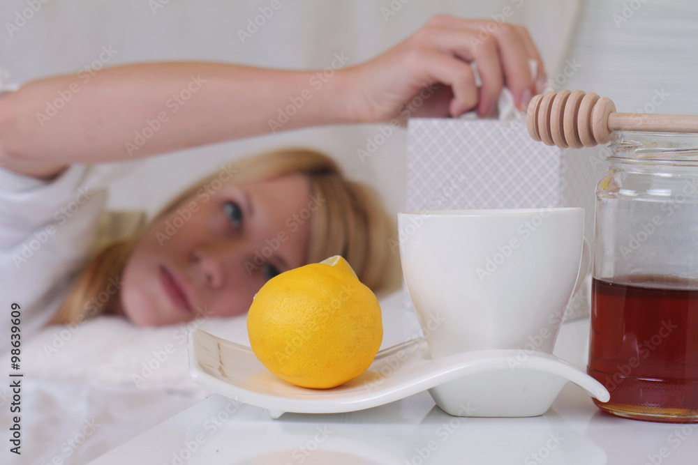 Woman caught cold ,running nose, selective focus. Flu and cold natural remedies , hot tea and honey Woman caught cold ,running nose, selective focus. Flu and cold natural remedies , hot tea and honey