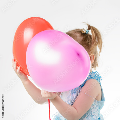Little girl in blue dress holding a balloon