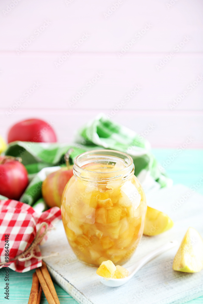 Apple jam in jar on a mint wooden table