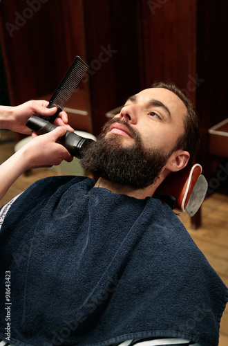 Man shaving his beard at the hairdresser