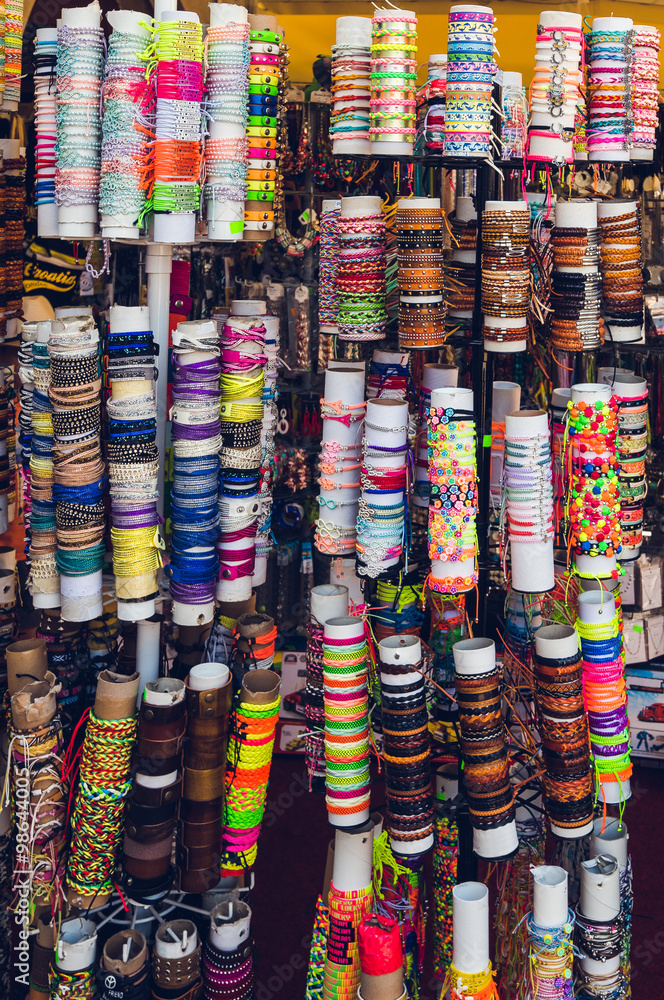 Many Different Colorful Bracelets in the Souvenir Shop on Paper Rolls