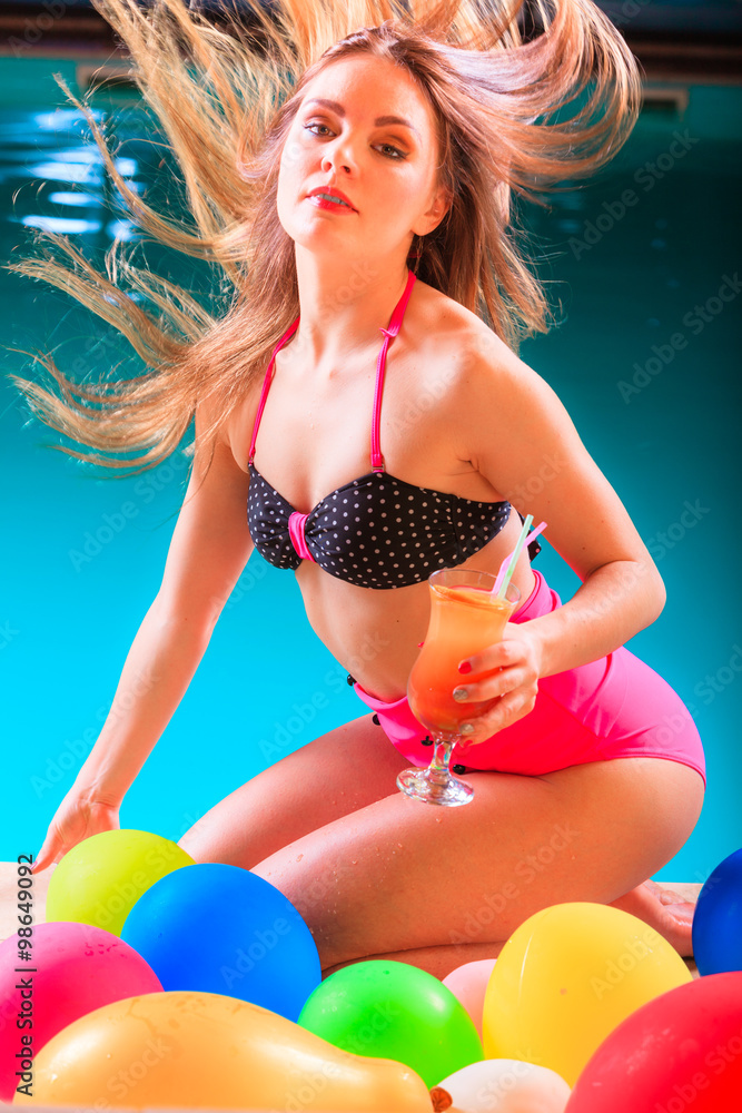 Happy woman with balloons and cocktail at poolside