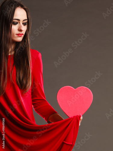 Woman red dress holds heart shaped box