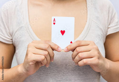 young woman holding in hand poker card with combination of Full