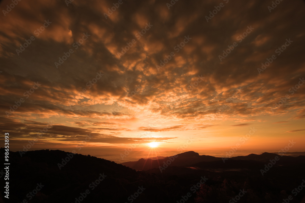 Beautiful sunset at the mountains. Colorful landscape with sun and