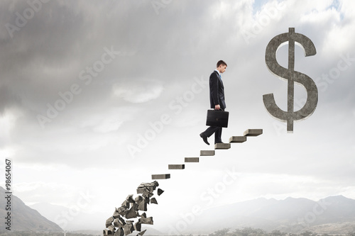 Businessman climbing stone ladder  photo