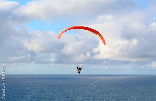 Hang Glider – Hang Glider flying in the sky on a bright blue day