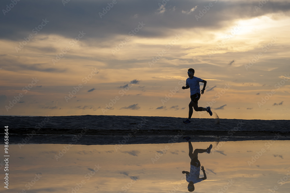 Man running on the beach at sunrise