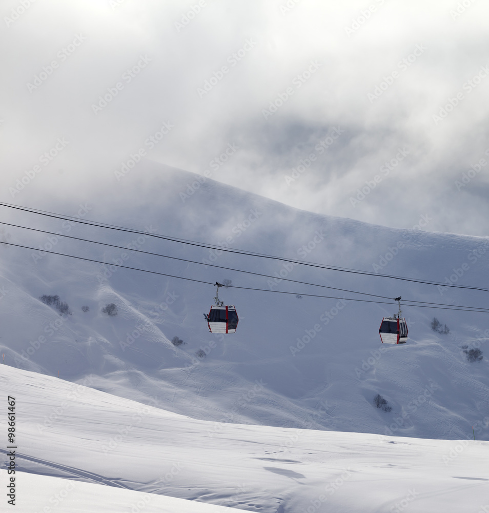 Gondola lifts and off-piste slope in mist Gondola lifts and off-piste slope in mist