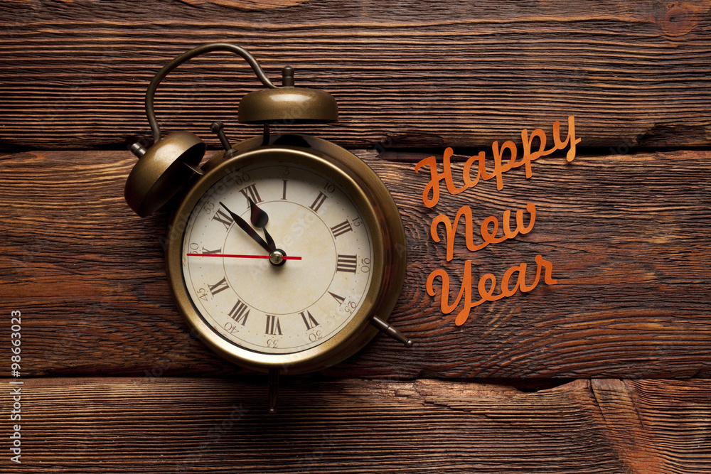 Happy new year - alarm clock on wooden background Happy new year - alarm clock on wooden background