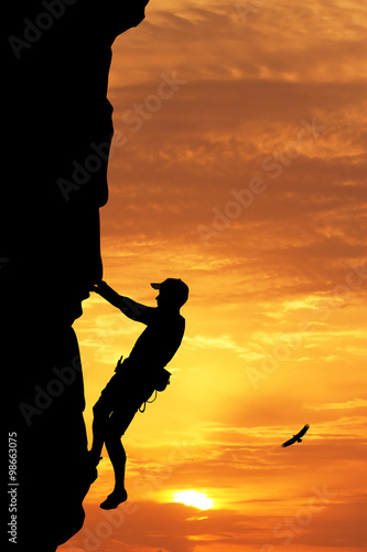 man climbs at sunset