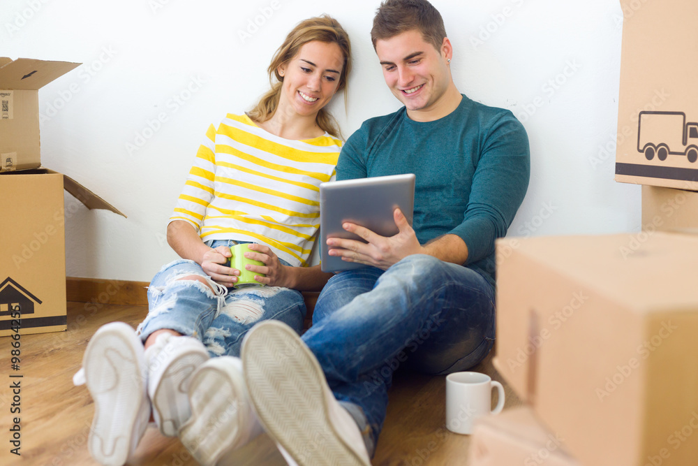 Young couple with digital tablet in their new home Young couple with digital tablet in their new home