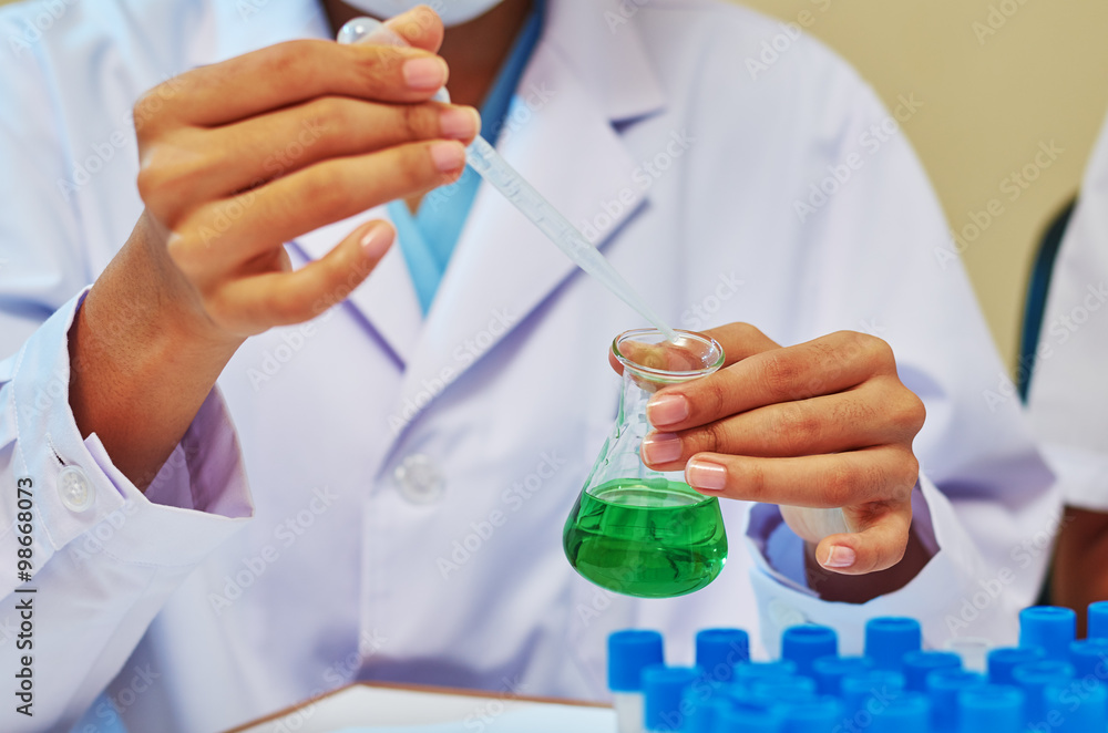 medical researcher pouring substance into a flask medical researcher pouring substance into a flask