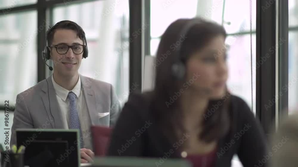 Professional in modern call center using headset and keyboard Professional in modern call center using headset and keyboard