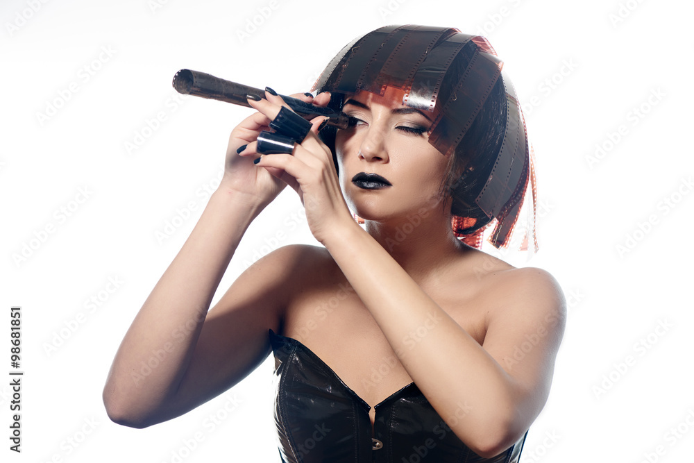 Beautiful stylish woman in leather corset in filmstrip wig looking in filmstrip roll isolated on white background Beautiful stylish woman in leather corset in filmstrip wig looking in filmstrip roll isolated on white background
