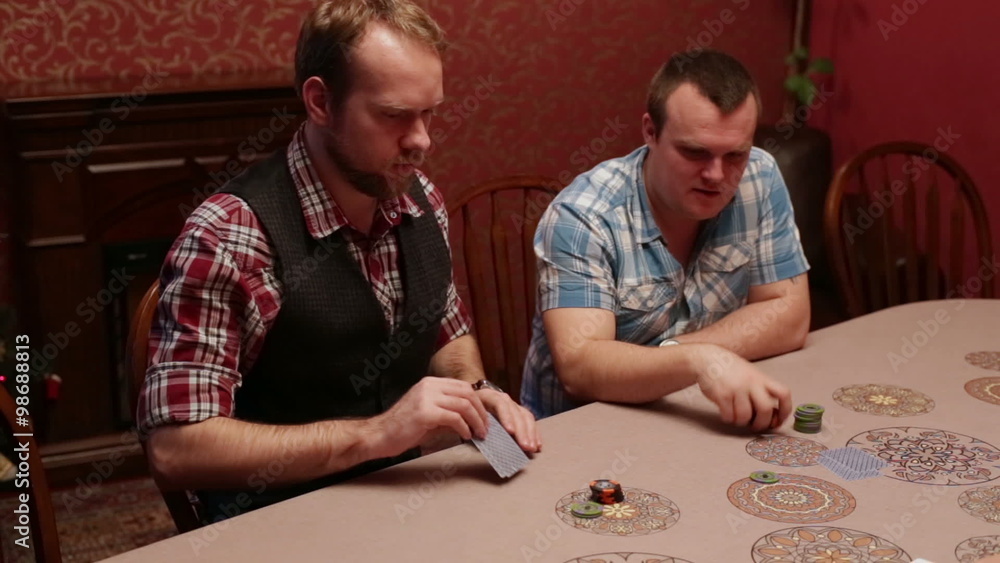 The men sitting at a table playing poker