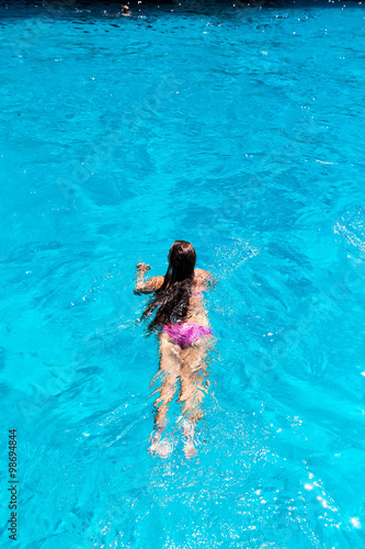 Young woman swimming in clear ocean water.