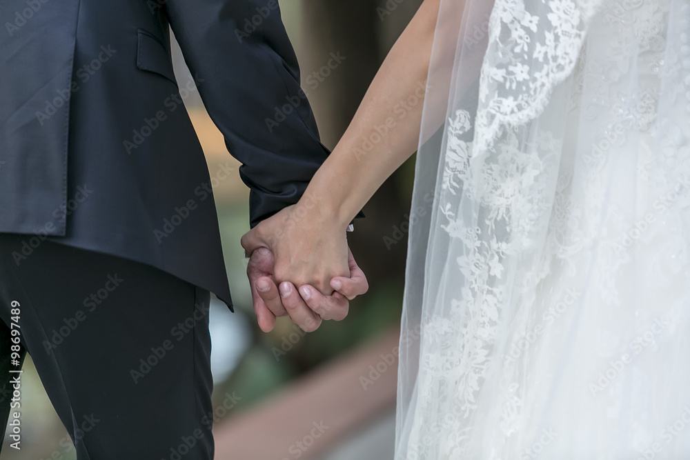Closeup of a bride and groom holding hands Closeup of a bride and groom holding hands