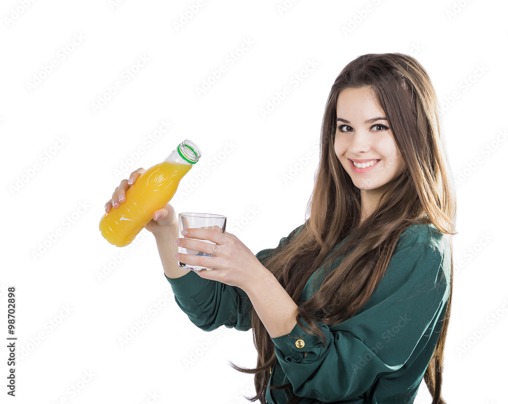 beautiful girl with dark hair pouring from a bottle into a glass of orange juice on a white background beautiful girl with dark hair pouring from a bottle into a glass of orange juice on a white background