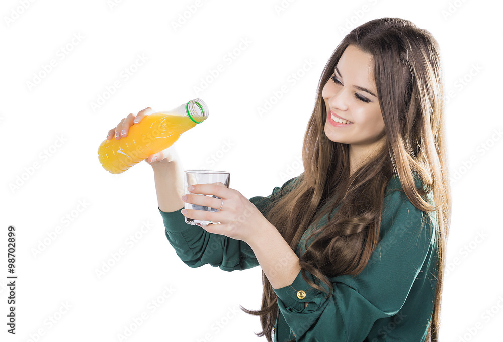 beautiful girl with dark hair pouring from a bottle into a glass of orange juice on a white background beautiful girl with dark hair pouring from a bottle into a glass of orange juice on a white background