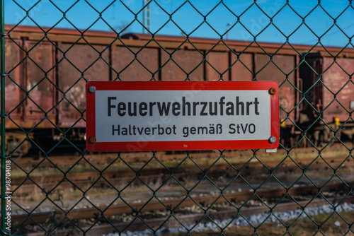 Hinweisschild Feuerwehrzufahrt an Maschendrahtzaun
