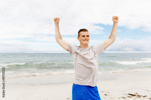 Young man in sport wear with outstretched arms