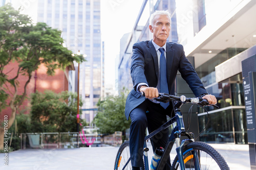 Successful businessman riding bicycle
