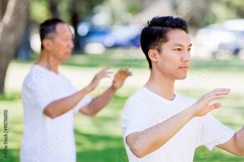 People practicing thai chi in park