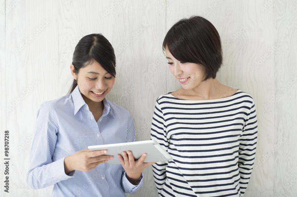 Two women are enjoying in the electronic tablet Two women are enjoying in the electronic tablet