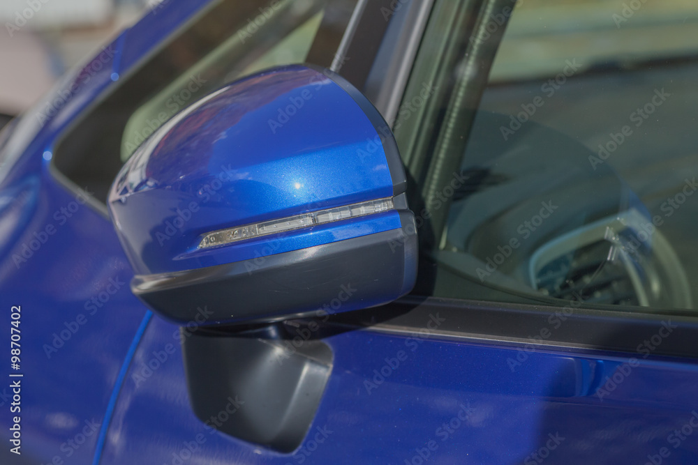 Fototapeta premium Side rear-view mirror closed for safety at car park..
