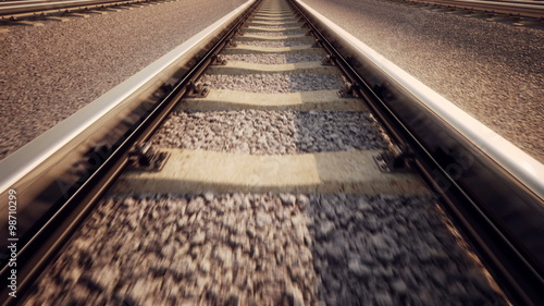 Railway tracks receding to a vanishing point in warm forward motion