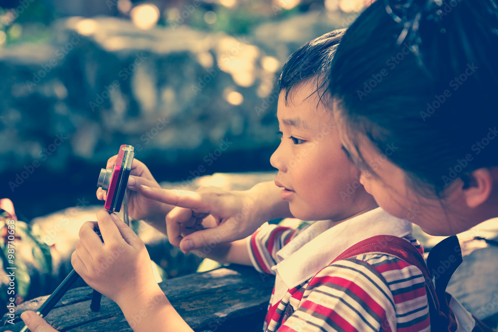 Obraz premium Happy family. Woman teaching boy photographing outdoors.