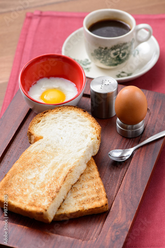 Breakfast set in consisting of coffee, toast bread and half-boiled egg