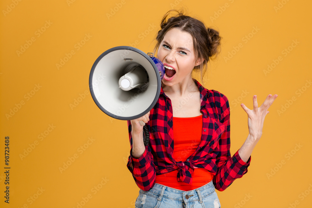Angry mad young woman screaming in megaphone Angry mad young woman screaming in megaphone