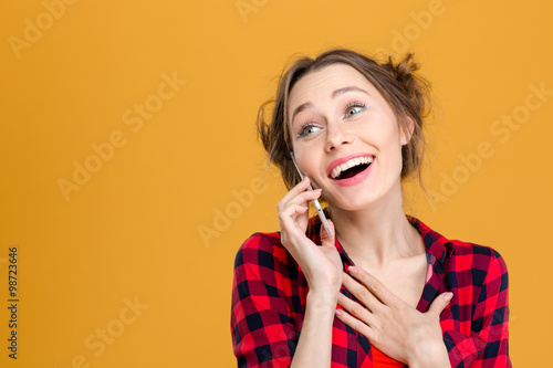 Smiling cute lovely young woman talking on mobile phone