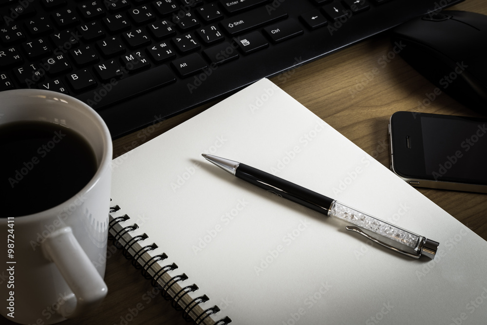 Pen on notebook with computer keyboard, mouse and cell phone Pen on notebook with computer keyboard, mouse and cell phone